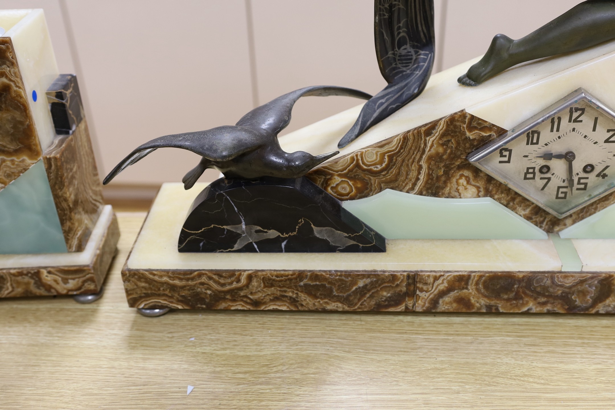 A large Art Deco spelter and marble clock garniture with a figural seaside mount, 59cm tall
